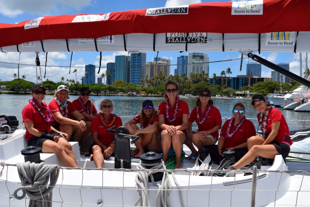 All smiles as Maiden sailors sit on deck, under the charity logos on the boom.